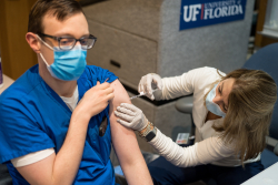 A UF Health worker receives his initial dose of a COVID-19 vaccine.