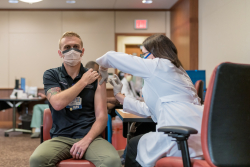 “I think it’s a step toward getting back to some kind of normal,’’ said Samuel J. Overly, B.S.N., R.N.-B.C., a trauma nurse and clinical leader in the UF Health adult emergency department, after receiving the inaugural vaccination.  Credit: Louis Brems