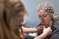 A participant gets fitted with an electrode net that monitors brain activity.