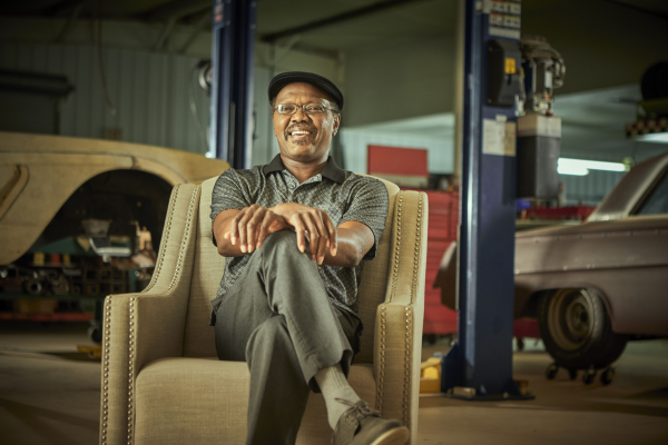 Jerry Nettles sits in a chair in a carshop