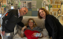 Heather Lowery laying in her hospital bed with Diego Moguillansky, MD, and Jana Reid, APRN, standing beside her.